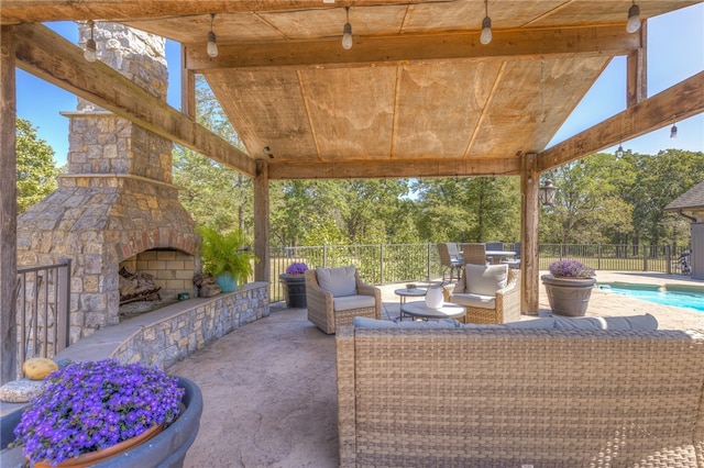 view of patio featuring a fenced in pool and an outdoor stone fireplace