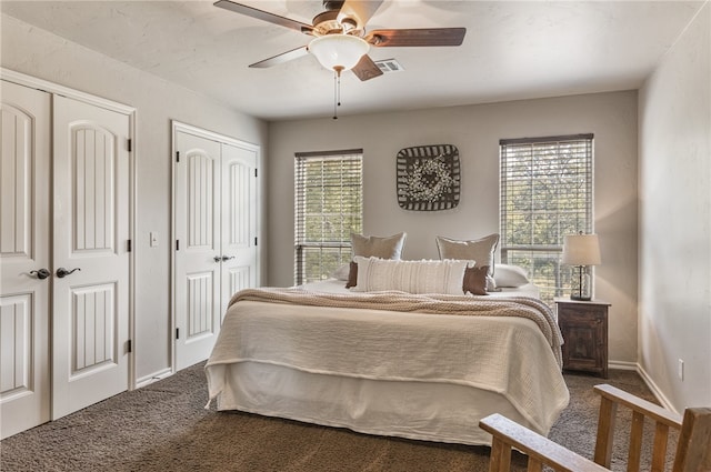 carpeted bedroom featuring two closets and ceiling fan