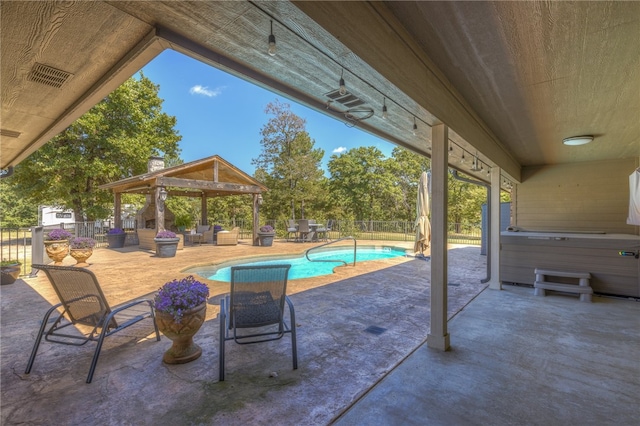 view of patio / terrace featuring a pool with hot tub and a gazebo