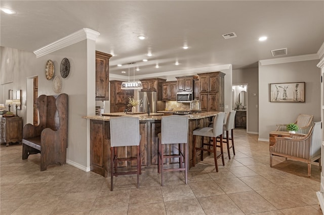 kitchen with ornamental molding, kitchen peninsula, stainless steel appliances, a breakfast bar area, and light stone countertops