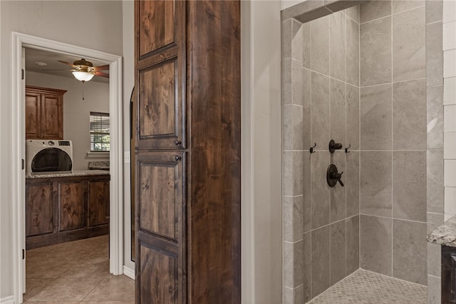 bathroom featuring washer / dryer, ceiling fan, tiled shower, and tile patterned floors