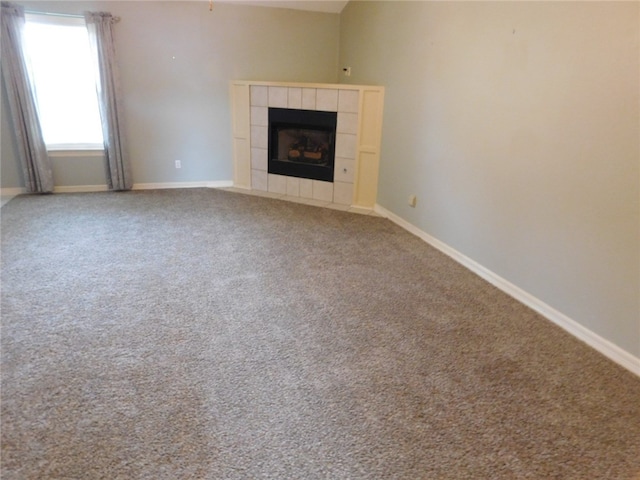 unfurnished living room with a tile fireplace and carpet flooring