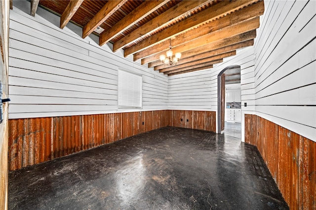 interior space featuring wood walls and a chandelier