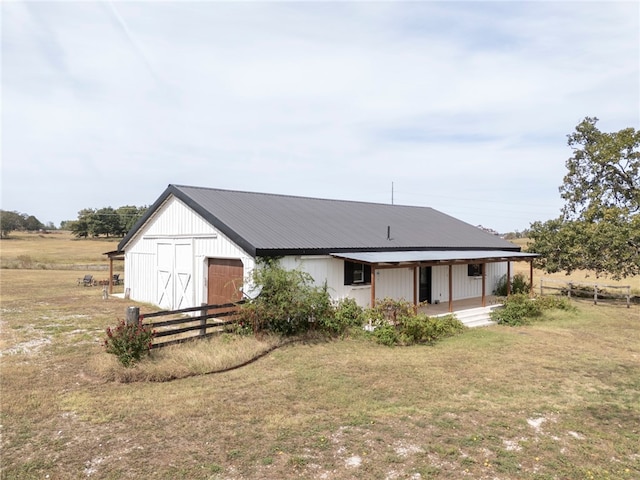 back of house with a lawn and an outbuilding