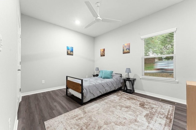 bedroom featuring visible vents, baseboards, ceiling fan, vaulted ceiling, and wood finished floors