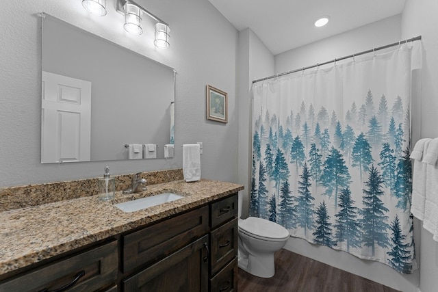 full bathroom with vanity, toilet, shower / bathtub combination with curtain, and hardwood / wood-style flooring