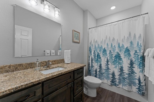 full bath featuring shower / bath combo with shower curtain, vanity, toilet, and wood finished floors