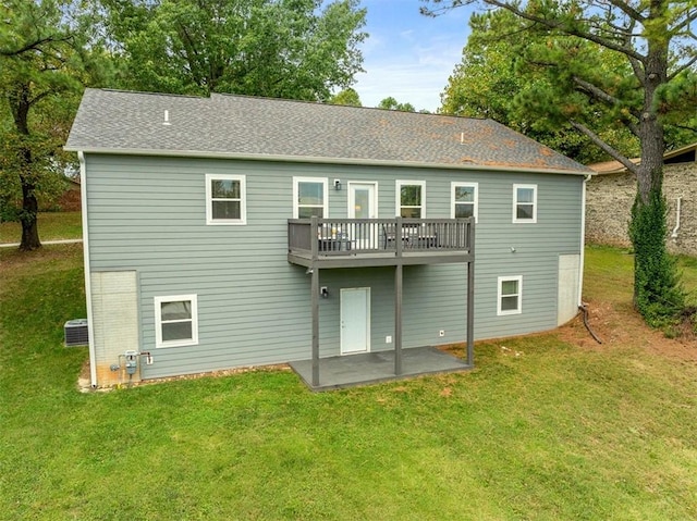rear view of property featuring a patio, a yard, and a shingled roof
