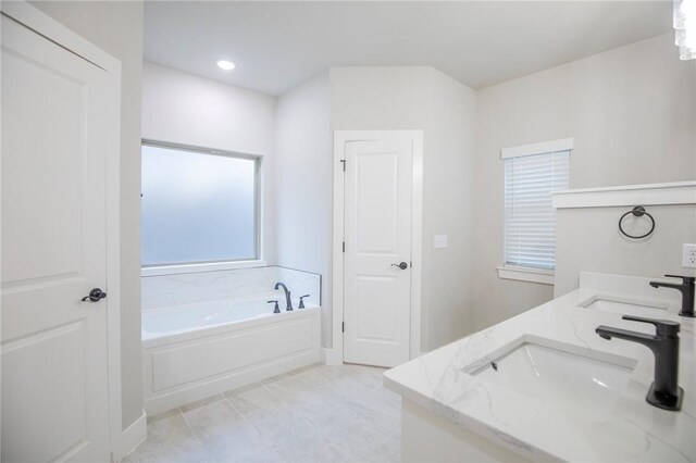 bathroom with vanity and a bath