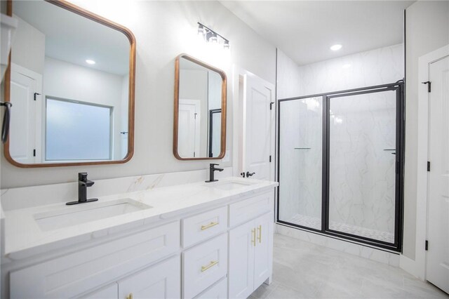 bathroom featuring a shower with door and vanity