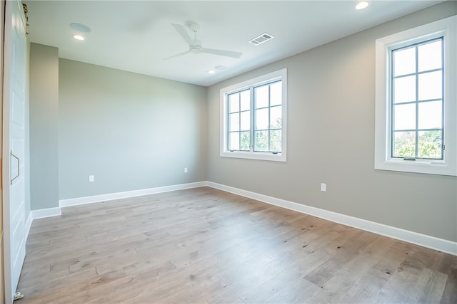 unfurnished room with light wood-type flooring, ceiling fan, and a wealth of natural light