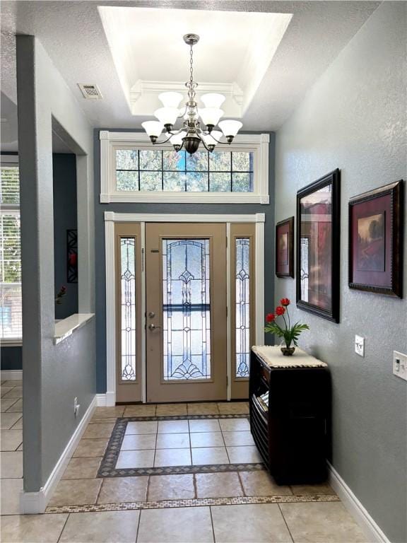 8825 Sky Watch Ln, Decatur, AR 72722 - entrance foyer with a tray ceiling, a chandelier, baseboards, light tile patterned flooring, and a textured wall
