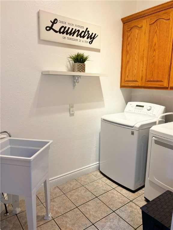 laundry room featuring cabinets, sink, light tile patterned flooring, and washing machine and dryer