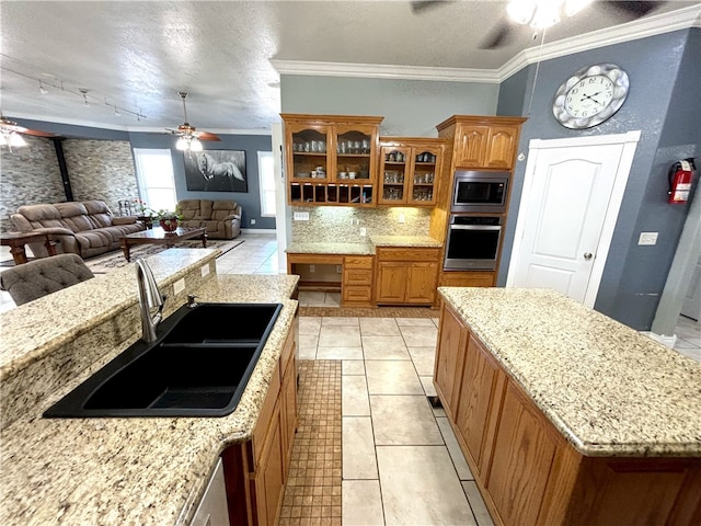 kitchen with appliances with stainless steel finishes, light tile patterned floors, ceiling fan, ornamental molding, and sink