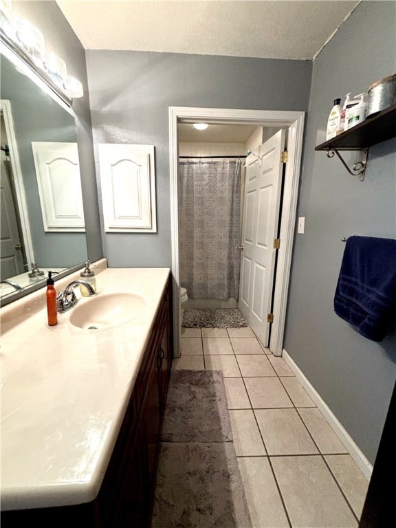 bathroom with a shower with curtain, vanity, tile patterned flooring, and toilet