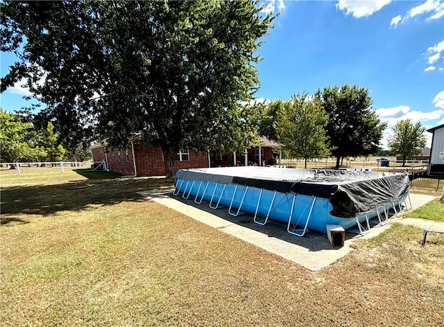 view of swimming pool featuring a yard