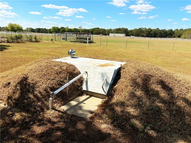 view of storm shelter with a rural view and a yard