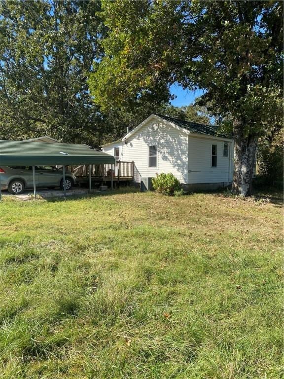 view of yard featuring a carport and a wooden deck