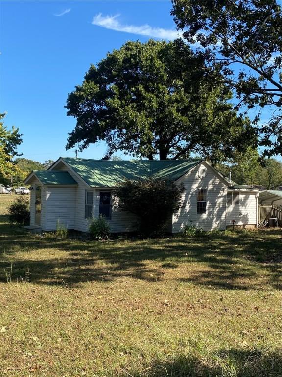 view of side of home with a yard