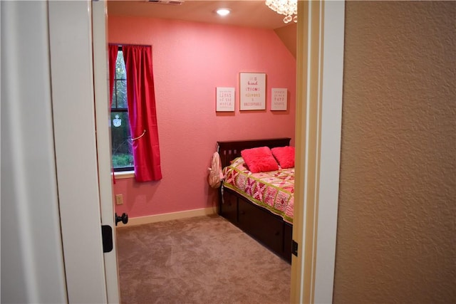 bedroom with lofted ceiling, carpet floors, and a chandelier