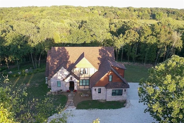 bird's eye view with a wooded view