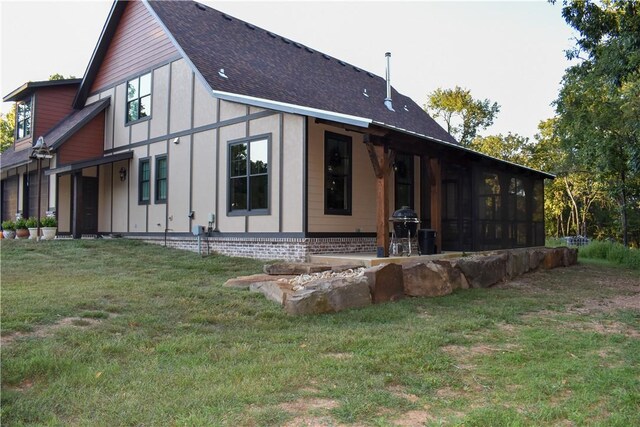 rear view of property with a sunroom and a lawn