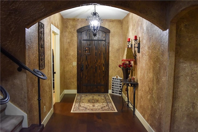 entrance foyer with dark hardwood / wood-style floors and a chandelier