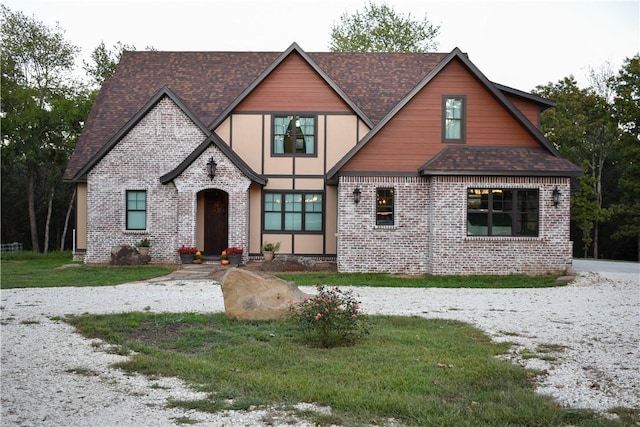 tudor house with a shingled roof and brick siding