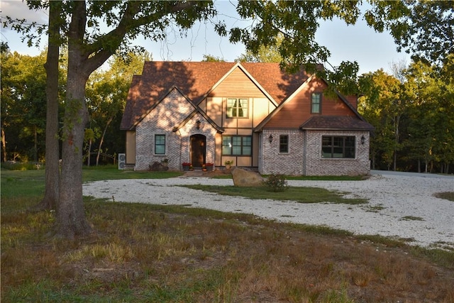 tudor-style house featuring a front yard