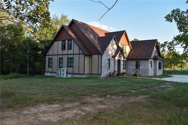 view of front of property with a front yard and ac unit