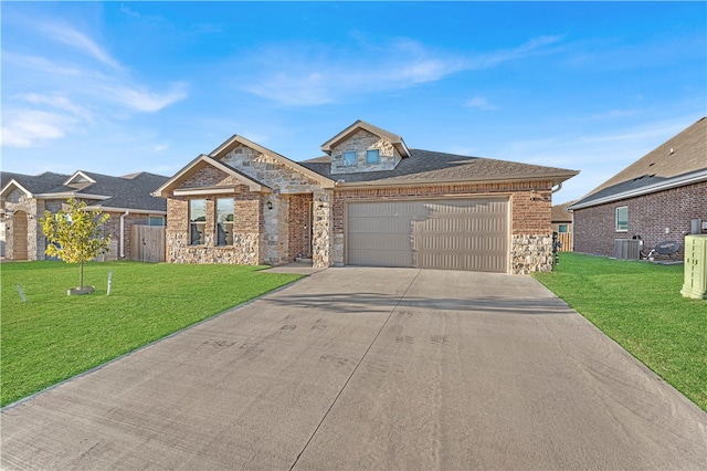 view of front of property featuring central AC unit, a front yard, and a garage