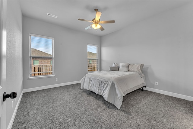 carpeted bedroom with ceiling fan and multiple windows