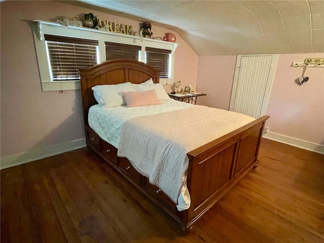 bedroom with vaulted ceiling and dark wood-type flooring