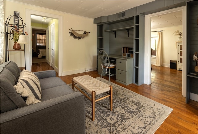 living room with wood-type flooring and crown molding