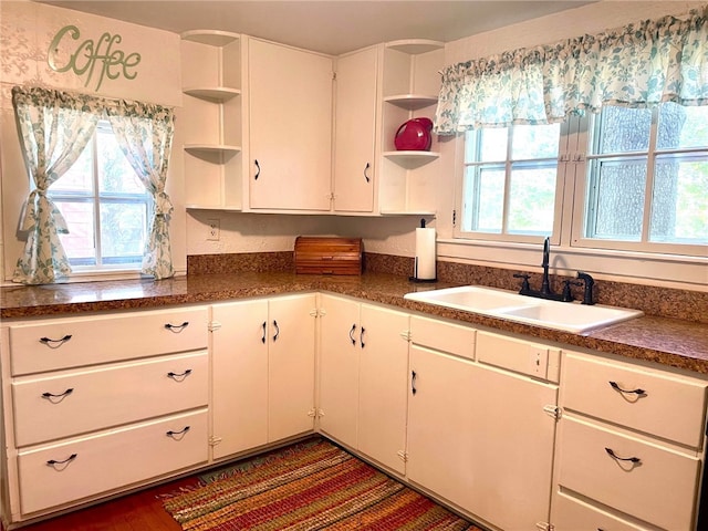 kitchen with white cabinets, sink, dark hardwood / wood-style flooring, and a wealth of natural light