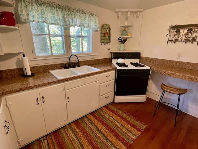 kitchen with white range with gas stovetop, white cabinetry, sink, and dark hardwood / wood-style flooring