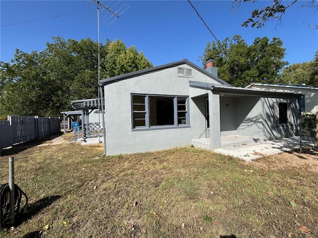 rear view of property with a patio and a yard