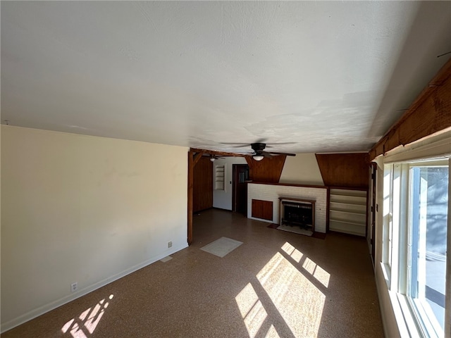 unfurnished living room with ceiling fan and a textured ceiling