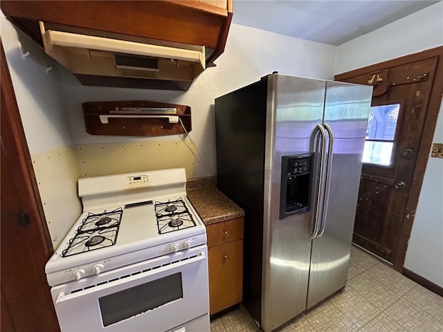 kitchen with stainless steel fridge, range hood, and white gas range