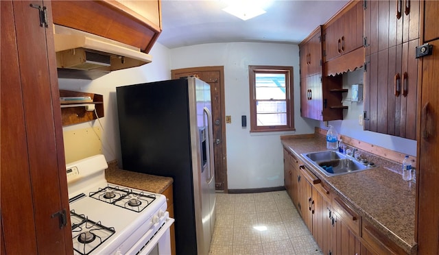 kitchen featuring white appliances, sink, and light tile patterned floors