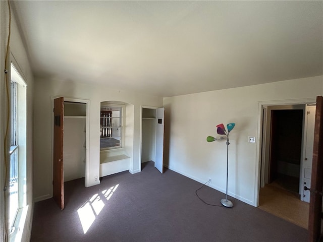 unfurnished bedroom with dark colored carpet