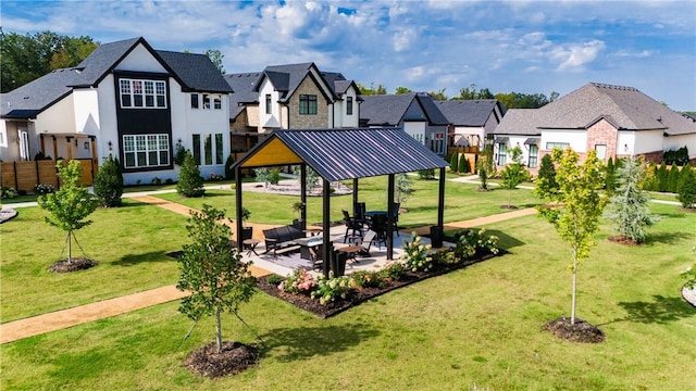 view of community with a patio area, a residential view, and a lawn