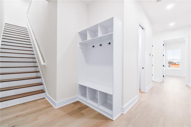 mudroom featuring baseboards, recessed lighting, and light wood-style floors