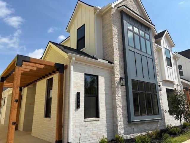 view of side of property with board and batten siding and brick siding