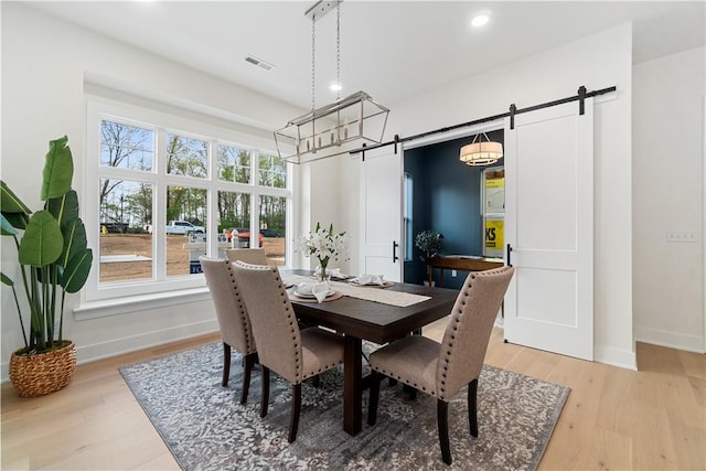 dining area featuring baseboards, recessed lighting, light wood-style floors, and a barn door