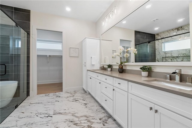 bathroom with a sink, double vanity, a stall shower, marble finish floor, and a walk in closet