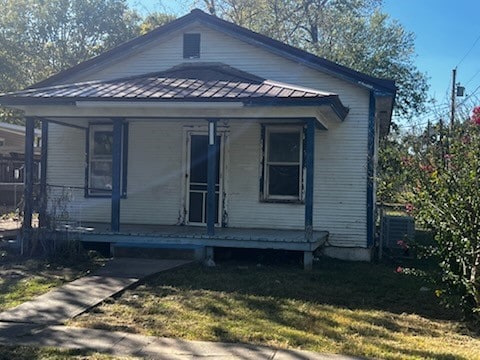 bungalow-style home with a front lawn and covered porch