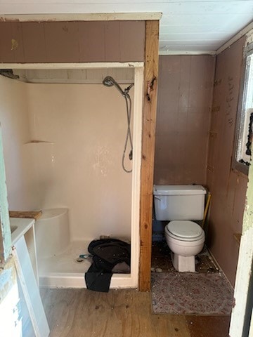 bathroom featuring walk in shower, hardwood / wood-style floors, and toilet