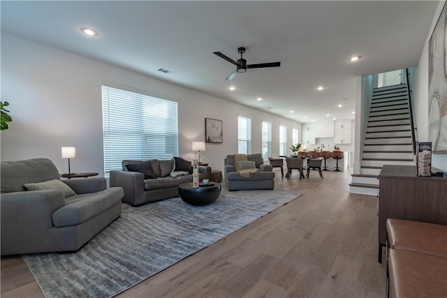 living room with light hardwood / wood-style floors and ceiling fan