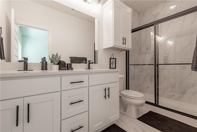 bathroom with an enclosed shower, vanity, and toilet